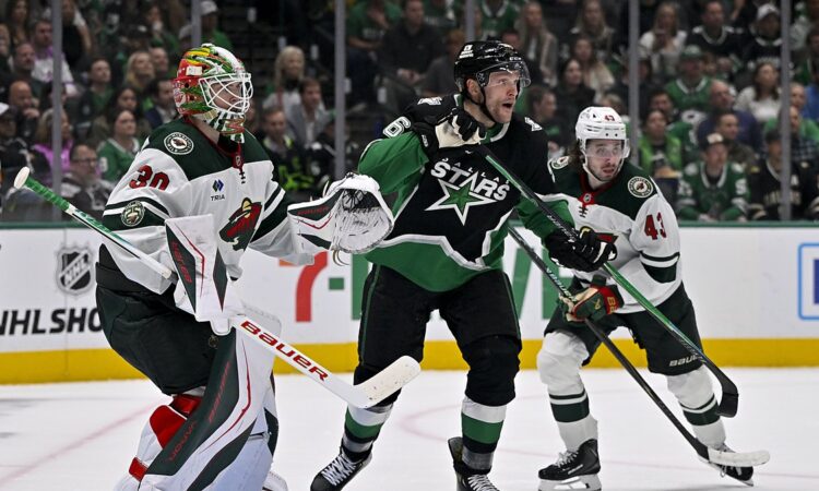 Stars right wing Mikko Rantanen skates in front of Wild goaltender Jesper Wallstedt as both watch the play.
