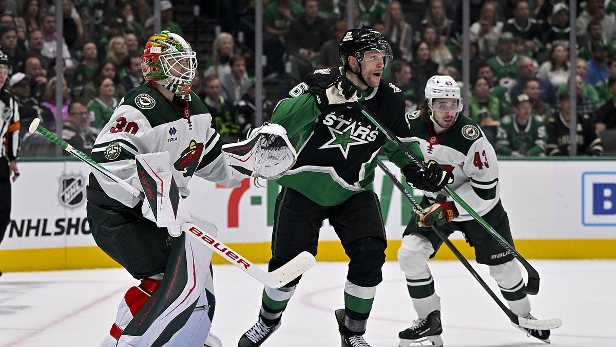 Stars right wing Mikko Rantanen skates in front of Wild goaltender Jesper Wallstedt as both watch the play.