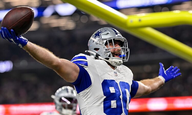Dallas Cowboys tight end Mitch Van Vooren spreads his arms and holds up the ball after scoring a touchdown.