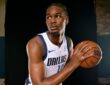Dallas Mavericks forward Morez Johnson Jr. holds a basketball and looks to his right in a white home jersey.