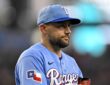 Texas Rangers starting pitcher Nathan Eovaldi walks off the field holding his glove during a game against the Padres.