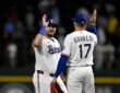 Rangers first baseman Jake Burger raises a hand to celebrate with pitcher Nathan Eovaldi after the final out.
