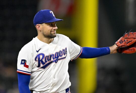 Rangers pitcher Nathan Eovaldi reaches out his glove for the ball on the mound.
