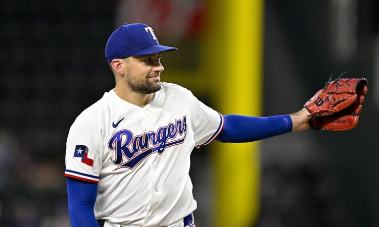 Rangers pitcher Nathan Eovaldi reaches out his glove for the ball on the mound.