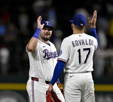 Rangers first baseman Jake Burger raises a hand to celebrate with pitcher Nathan Eovaldi after the final out.