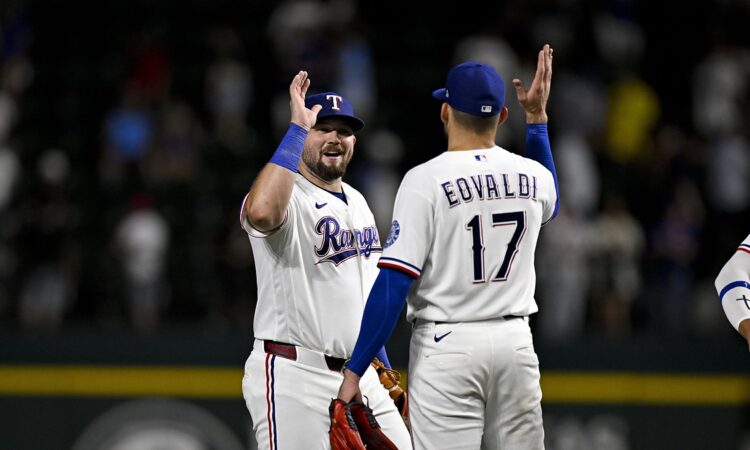 Rangers first baseman Jake Burger raises a hand to celebrate with pitcher Nathan Eovaldi after the final out.