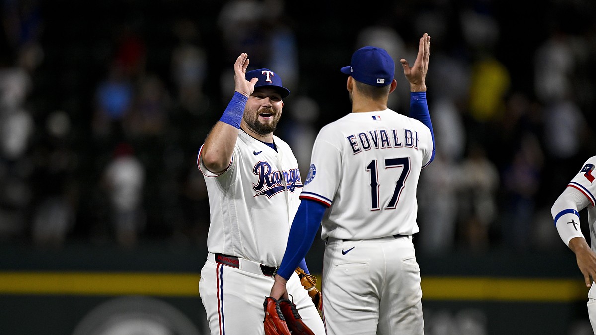 Rangers first baseman Jake Burger raises a hand to celebrate with pitcher Nathan Eovaldi after the final out.