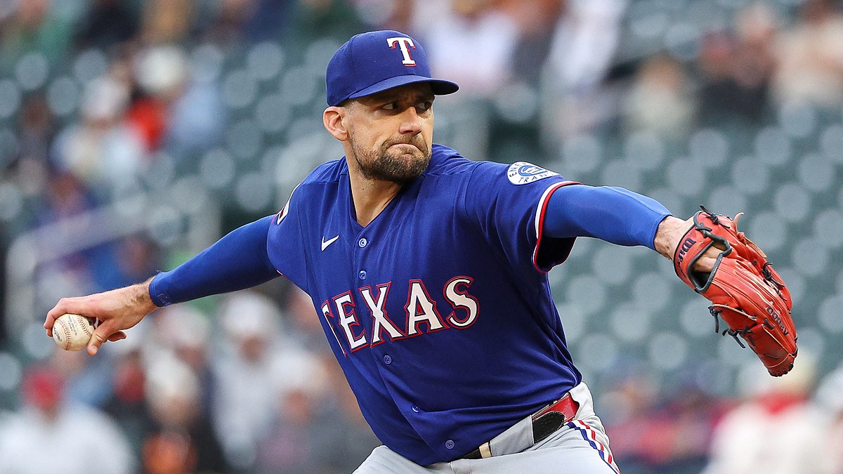 Texas Rangers starting pitcher Nathan Eovaldi extends his glove arm and brings the ball forward mid-delivery.