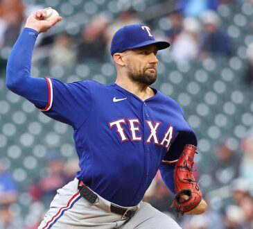 Texas Rangers starting pitcher Nathan Eovaldi rears back with the ball raised overhead as he delivers a pitch.