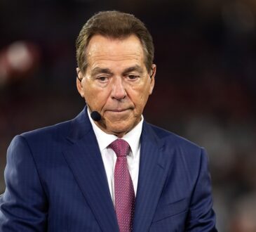 ESPN analyst Nick Saban wears a headset microphone while working on the broadcast set during a game.