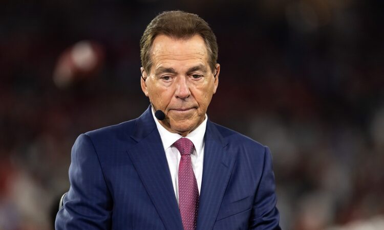 ESPN analyst Nick Saban wears a headset microphone while working on the broadcast set during a game.