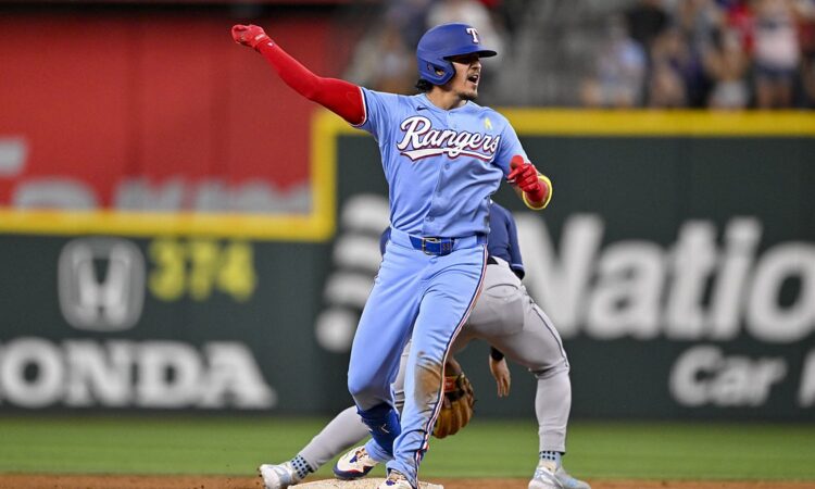 Texas Rangers infielder Nicky Lopez thrusts a fist toward the dugout after reaching second base against the Rays.