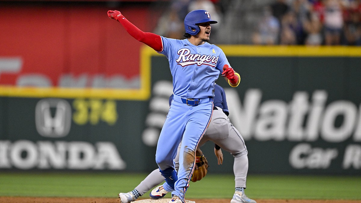 Texas Rangers infielder Nicky Lopez thrusts a fist toward the dugout after reaching second base against the Rays.