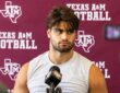 Texas A&M's Noah Mikhail sits in front of a Texas A&M Football backdrop while speaking to reporters.