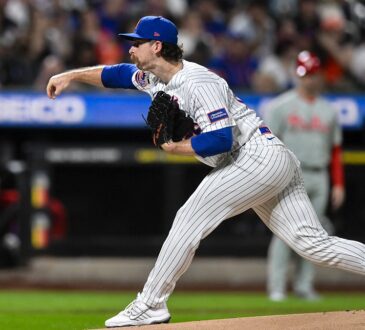 New York Mets starting pitcher Nolan McLean follows through on a pitch in a pinstriped Mets home uniform.