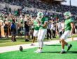 A North Texas player bows his head with his hands together in the end zone after a touchdown against UNLV.