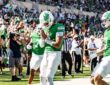 A North Texas player bows his head with his hands together in the end zone after a touchdown against UNLV.