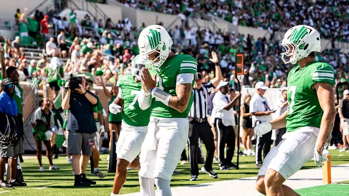 A North Texas player bows his head with his hands together in the end zone after a touchdown against UNLV.