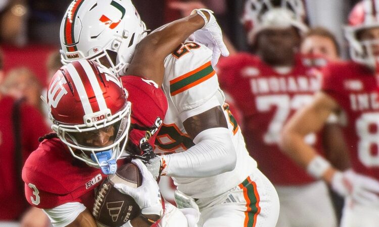 Indiana receiver Omar Cooper Jr. secures the ball as Miami defensive back OJ Frederique Jr. wraps him up.