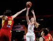 United States guard Paige Bueckers, No. 4, releases a jump shot as China center Han Xu contests with both arms raised.