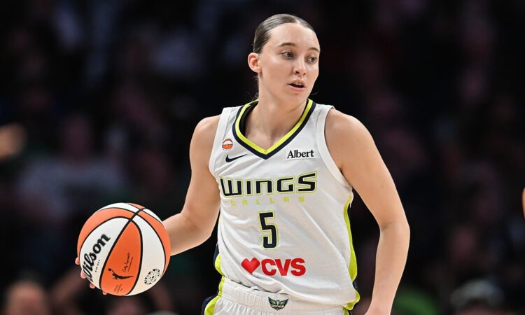 Dallas Wings guard Paige Bueckers dribbles up the floor in her white road uniform at Target Center.