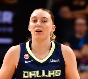 Dallas Wings guard Paige Bueckers dribbles up the court in a navy Dallas jersey during a road game.