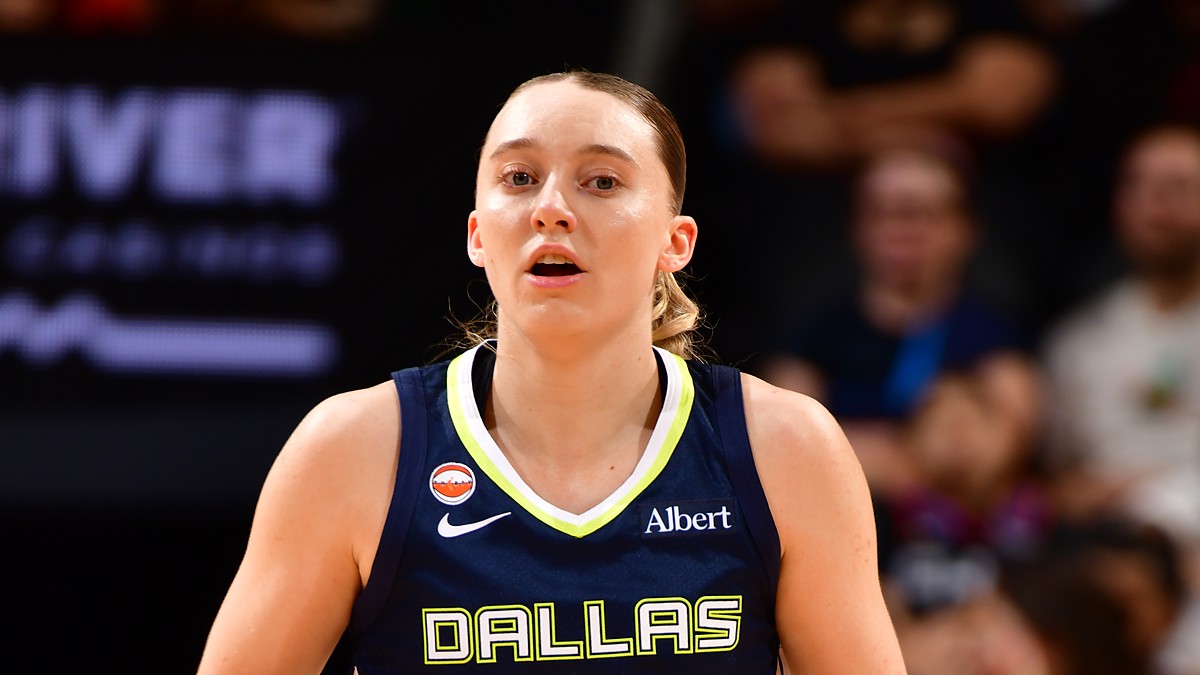 Dallas Wings guard Paige Bueckers dribbles up the court in a navy Dallas jersey during a road game.