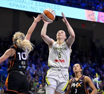 Dallas Wings guard Paige Bueckers rises for a shot as Phoenix Mercury guard Alexa Held reaches in to contest.