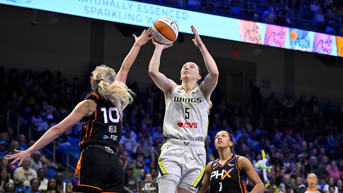 Dallas Wings guard Paige Bueckers rises for a shot as Phoenix Mercury guard Alexa Held reaches in to contest.