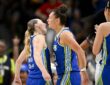 Dallas Wings guard Paige Bueckers and forward Jessica Shepard celebrate face to face as a teammate claps.