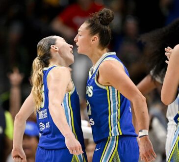 Dallas Wings guard Paige Bueckers and forward Jessica Shepard celebrate face to face as a teammate claps.