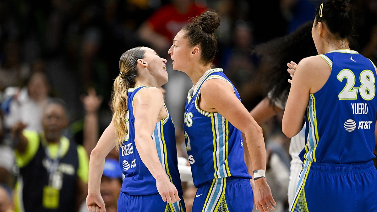 Dallas Wings guard Paige Bueckers and forward Jessica Shepard celebrate face to face as a teammate claps.