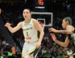 Dallas Wings guard Paige Bueckers flicks a pass as a Seattle Storm defender closes in.