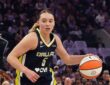Dallas Wings guard Paige Bueckers dribbles to her left as two Golden State Valkyries defenders close in.