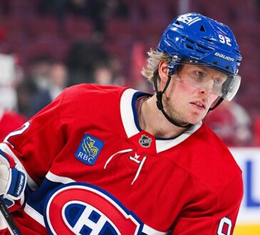 Montreal Canadiens right wing Patrik Laine holds his stick during warmups in a red home sweater.