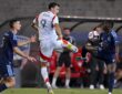 FC Dallas forward Petar Musa leaps for the ball as two Sporting Kansas City players challenge him.