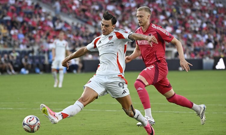 FC Dallas forward Petar Musa strikes the ball as St. Louis CITY SC defender Timo Baumgartl closes in.