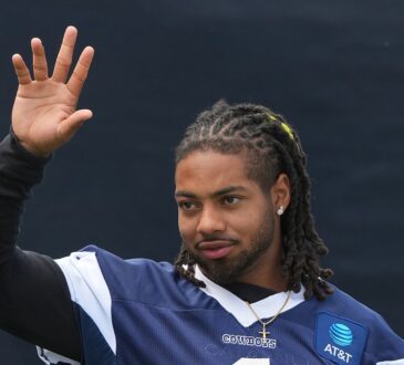 Cowboys safety P.J. Locke raises a hand during a break at training camp.