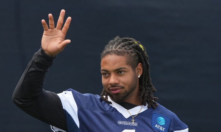 Cowboys safety P.J. Locke raises a hand during a break at training camp.