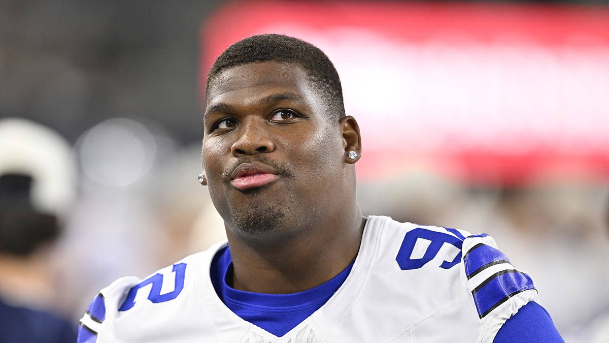 Dallas Cowboys defensive tackle Quinnen Williams looks upward while standing without his helmet.