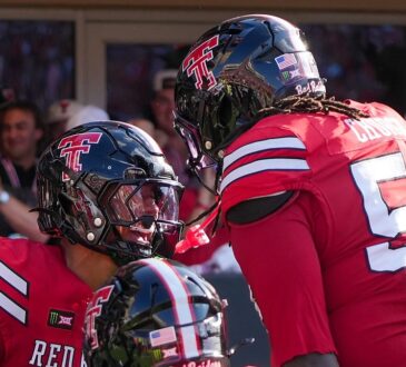 Texas Tech's Quinten Joyner and Jordan Church face each other helmet to helmet celebrating a touchdown.