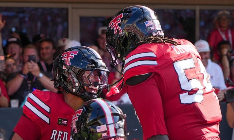 Texas Tech's Quinten Joyner and Jordan Church face each other helmet to helmet celebrating a touchdown.