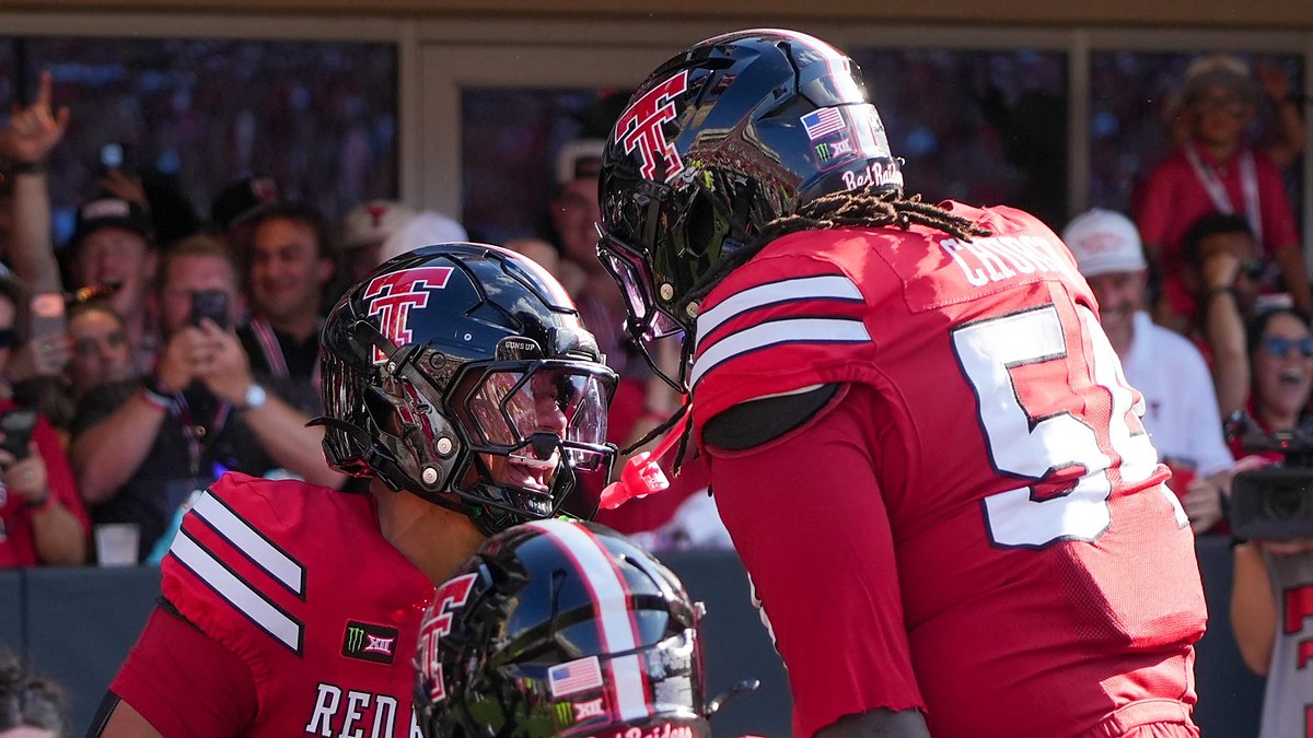 Texas Tech's Quinten Joyner and Jordan Church face each other helmet to helmet celebrating a touchdown.