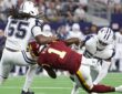 Washington Commanders running back Rachaad White is spun backward as two Dallas Cowboys linebackers bring him down.