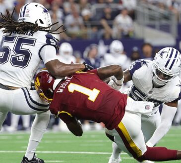 Washington Commanders running back Rachaad White is spun backward as two Dallas Cowboys linebackers bring him down.
