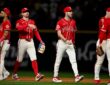 Texas Rangers players walk off the field together after a win, one raising his hand for a high-five.