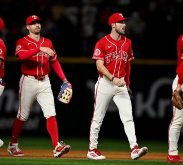 Texas Rangers players walk off the field together after a win, one raising his hand for a high-five.