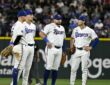 Texas Rangers infielders Josh Jung, Corey Seager, Jacob Burger, and Justin Foscue gather on the infield during a pause.