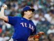 A Texas Rangers pitcher raises the ball in his delivery during a game against the Seattle Mariners.