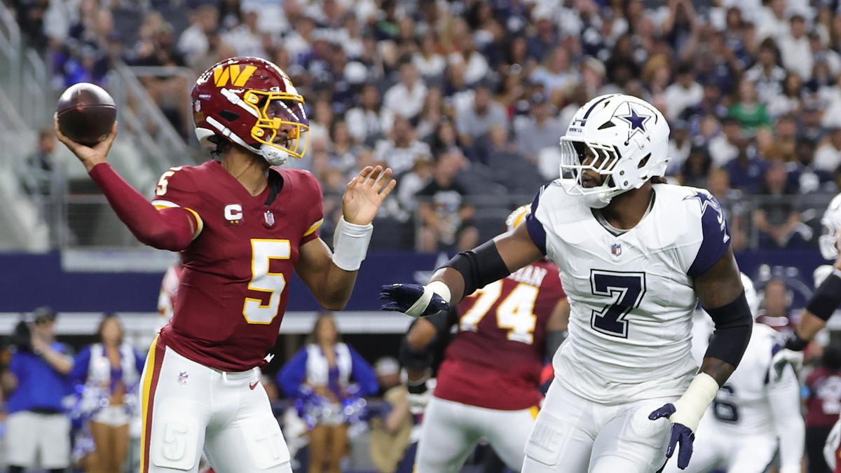 Washington Commanders quarterback Jayden Daniels throws a pass as Cowboys linebacker Rashan Gary rushes toward him.